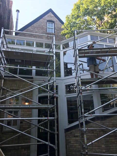 A building with scaffolding around it and trees in the background.