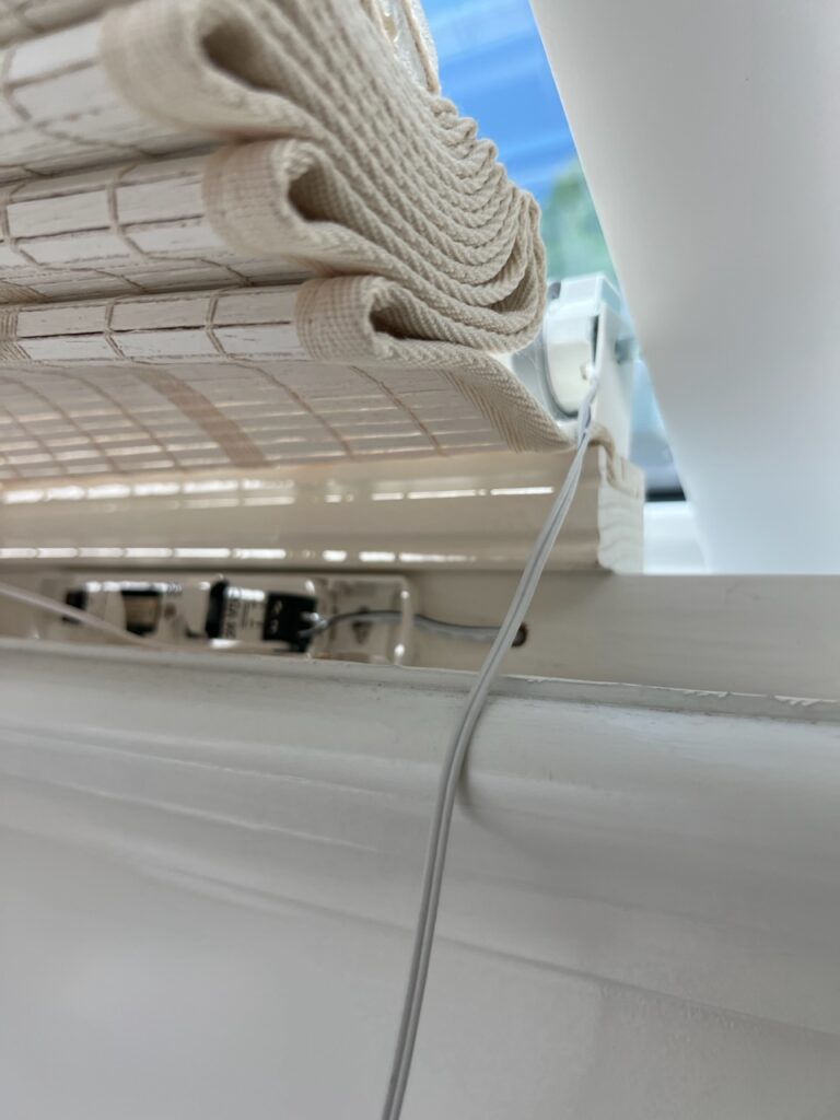 A white air conditioner with two rolls of paper hanging from it.