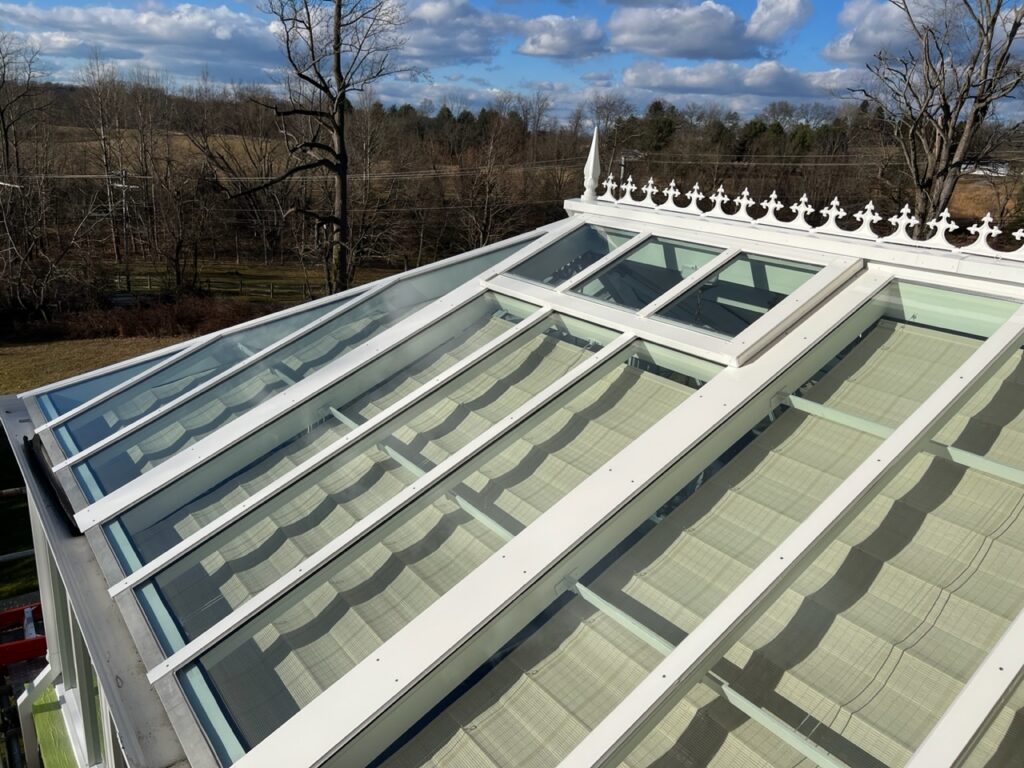 A roof with glass windows and a white frame.